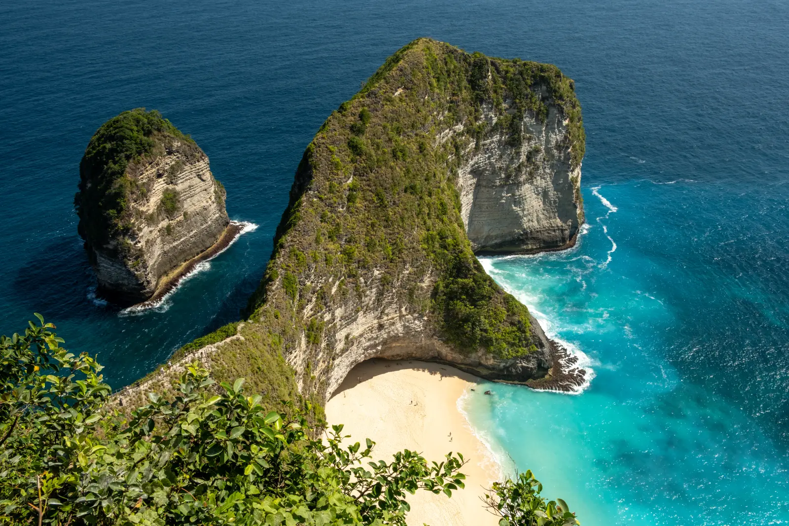 The headland at Kelingking Beach, Nusa Penida, above a small sandy bay.